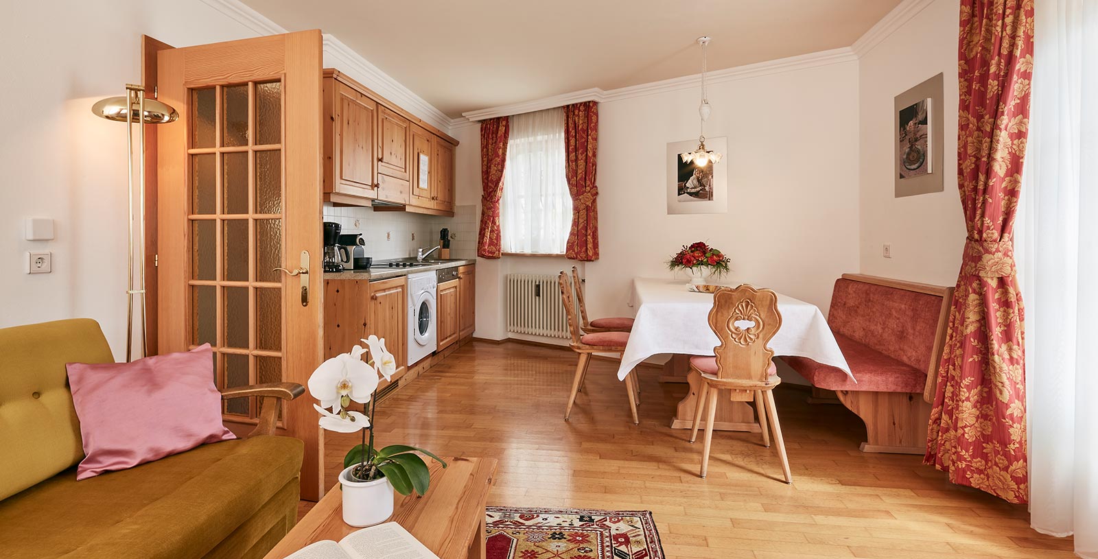 Kitchen-cum-living room of a holiday apartment of the Chalet Cristina with typical wooden bench